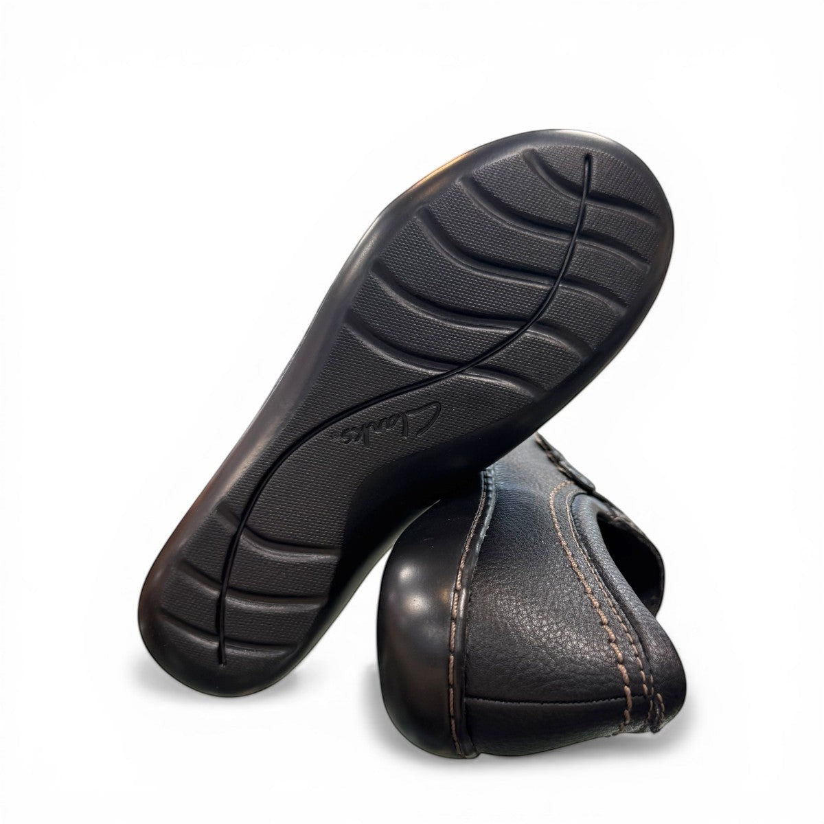 Clarks Ashland Effie black leather slip-on shoe with round toe and decorative button detail. bottom view.