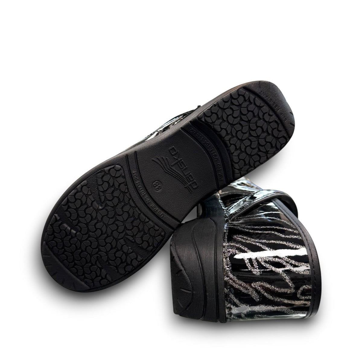 Dansko XP 2.0 patent clog showing the black slip-resistant rubber outsole and glitter wave pattern.