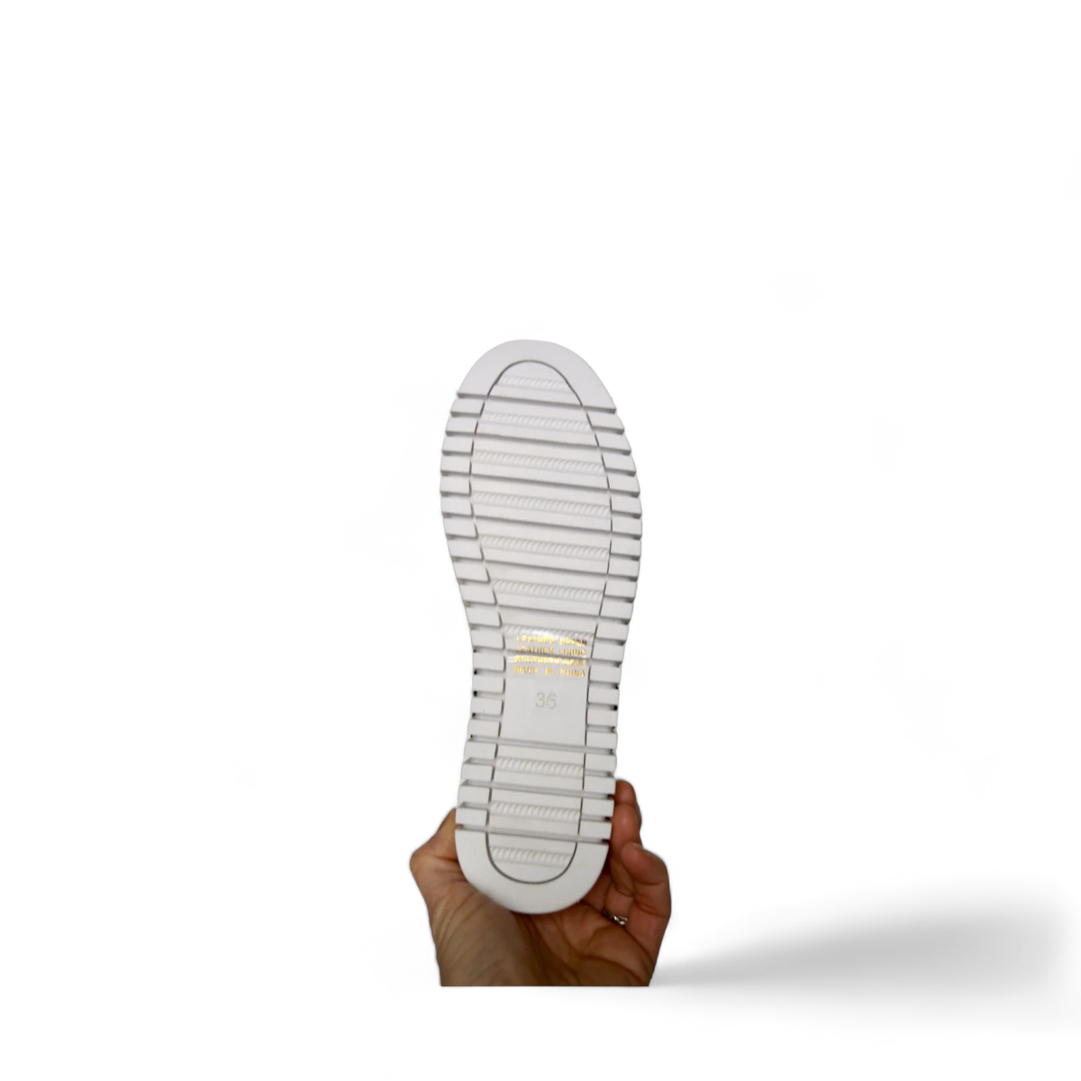 Django & Juliette white leather slip-on sneakers with perforated upper and thick cleated sole. Photo of bottom view.