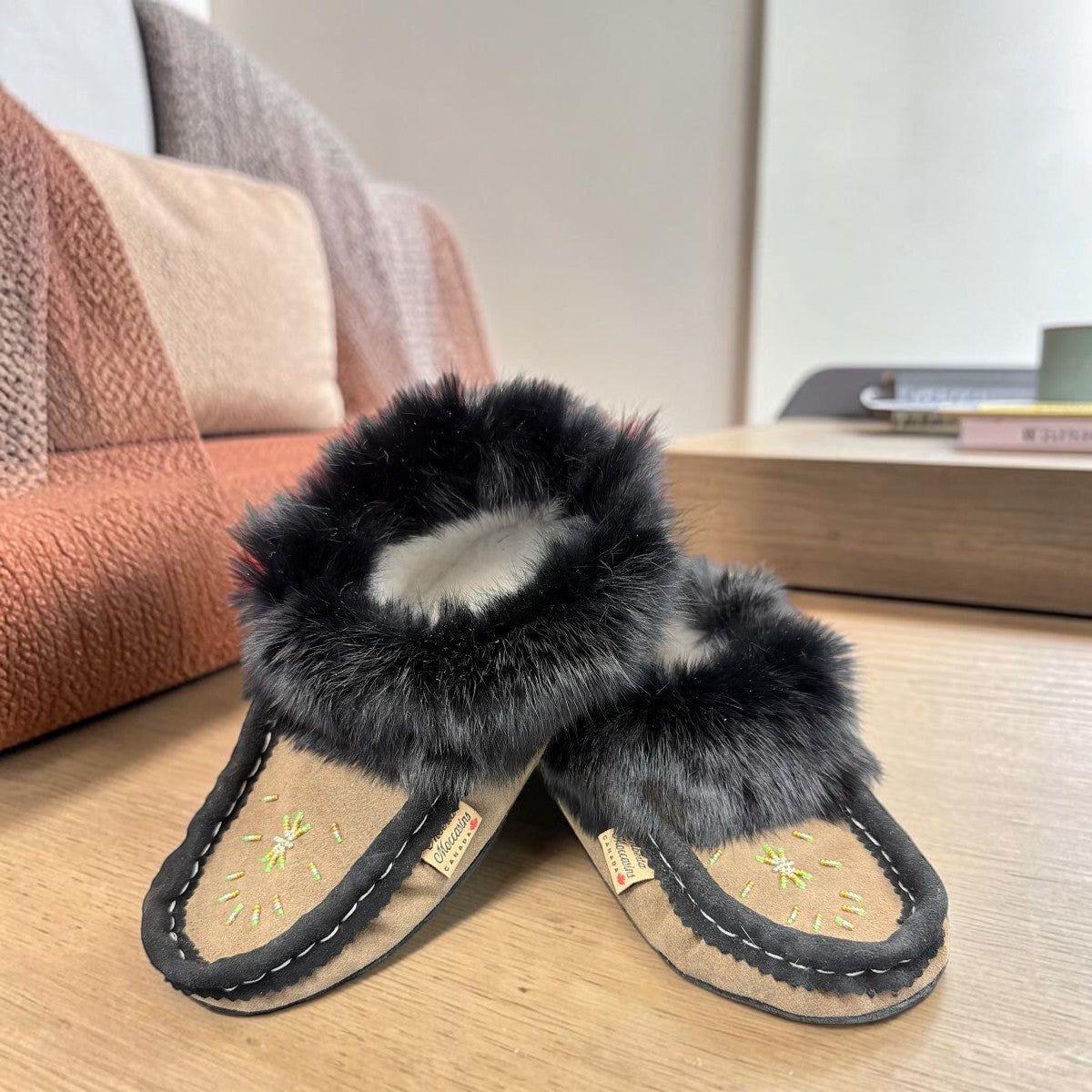 Alberta coffee brown suede moccasin with a plush black rabbit fur ankle collar. Photo of front side view.