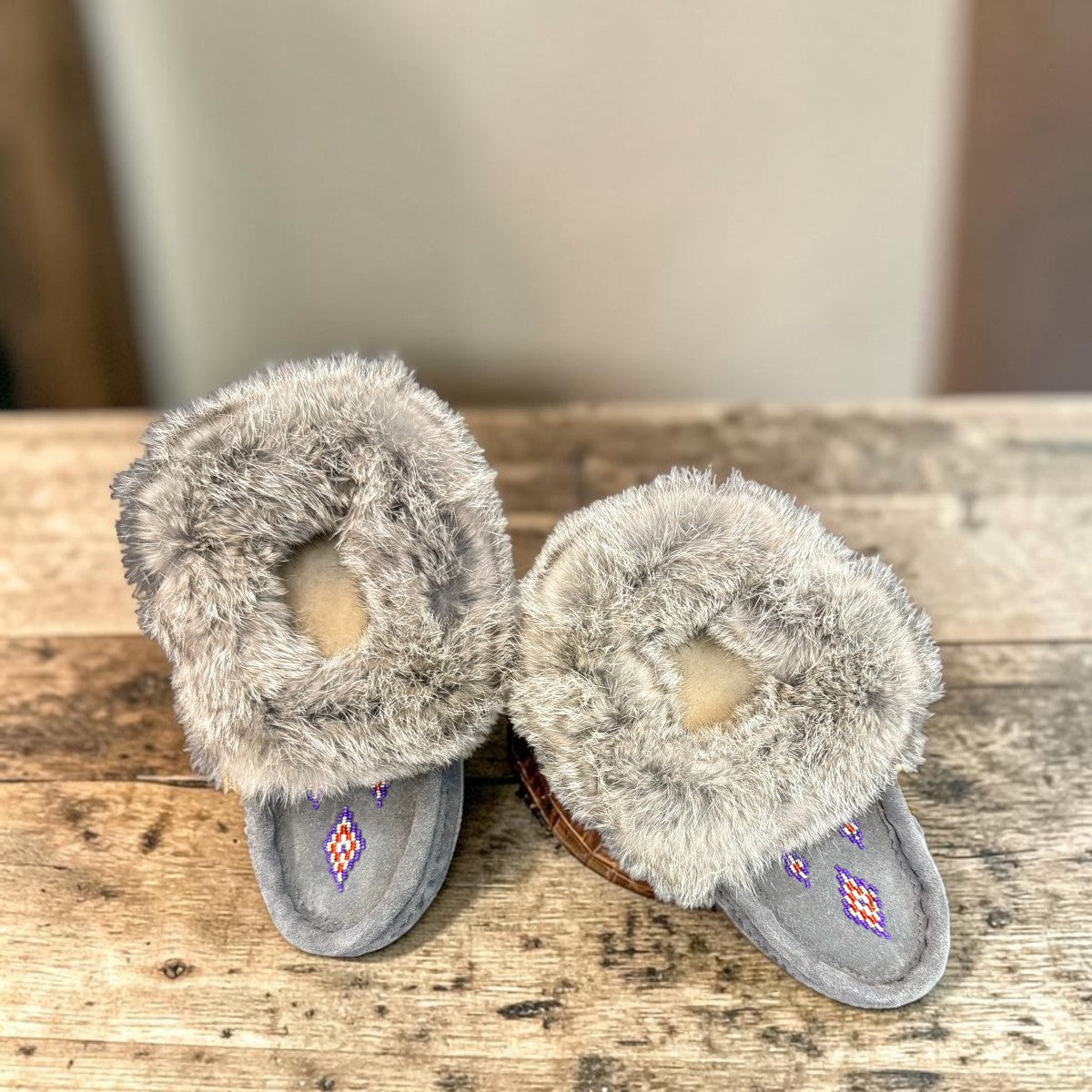 Alberta dark grey suede moccasins with a plush rabbit fur ankle collar, handcrafted for comfort. Photo of upper view.
