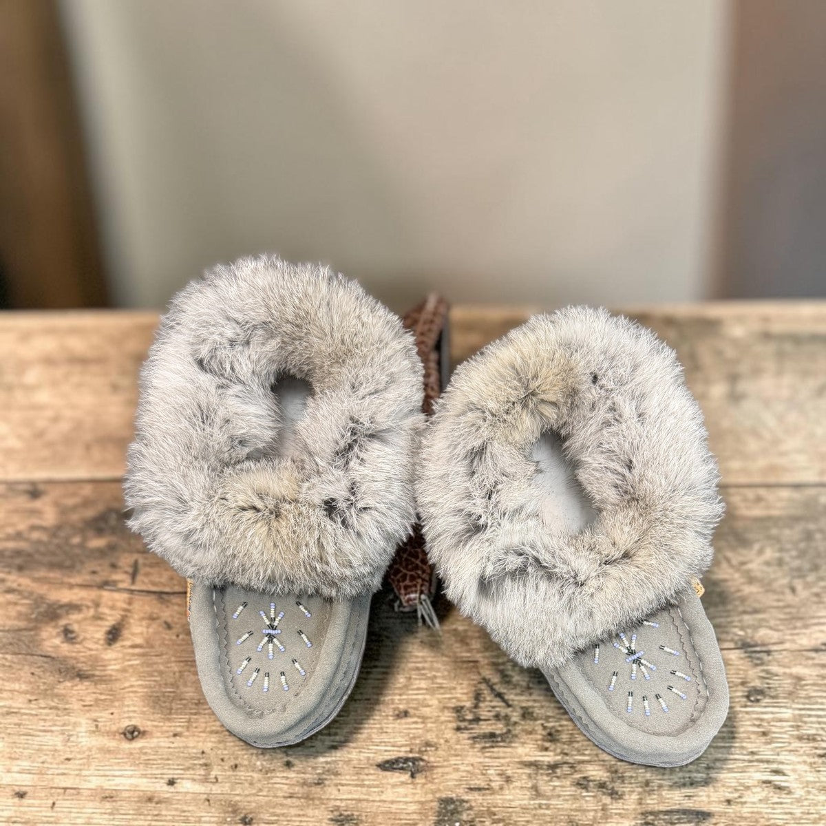 Alberta light grey suede moccasin with a fluffy rabbit fur ankle collar, handcrafted side view. Photo of upper view.