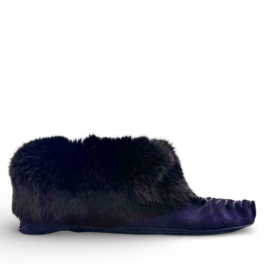 Alberta navy cowhide suede moccasins with a plush black rabbit fur ankle collar, handcrafted design.
photo of the right side