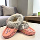 Alberta pink suede moccasins with a soft rabbit fur ankle collar, handcrafted for cozy comfort. Photo of front side view.
