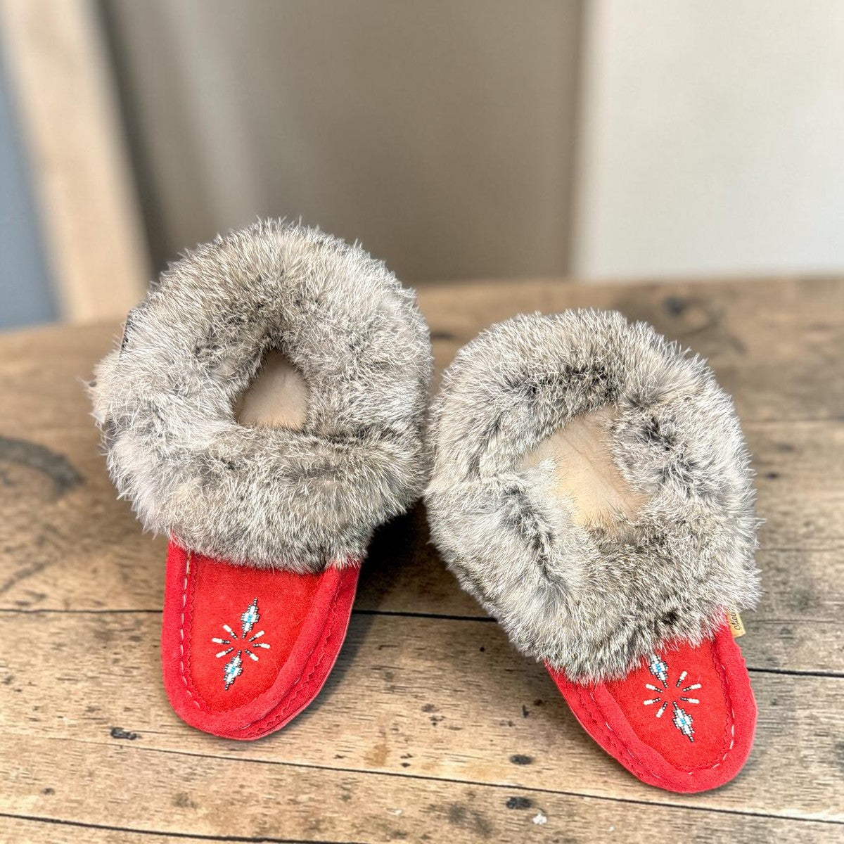 Alberta red suede moccasins with a fluffy rabbit fur ankle collar, handcrafted for cozy comfort. Photo of upper view.