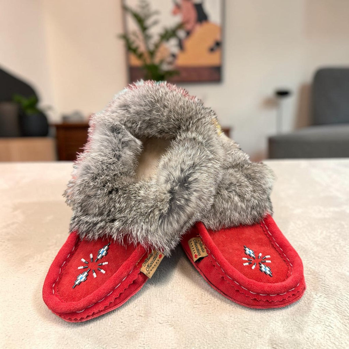 Alberta red suede moccasins with a fluffy rabbit fur ankle collar, handcrafted for cozy comfort. Photo of front side view.