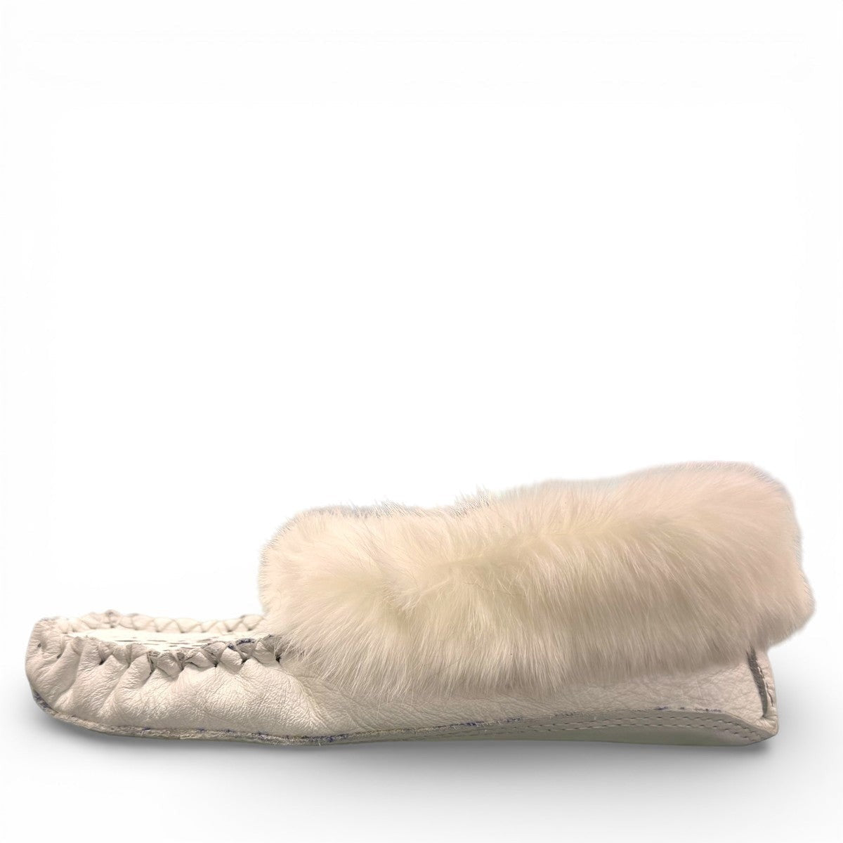 Alberta  white leather moccasins featuring a plush fur collar and side brand tag, side view.
photo of the left side
