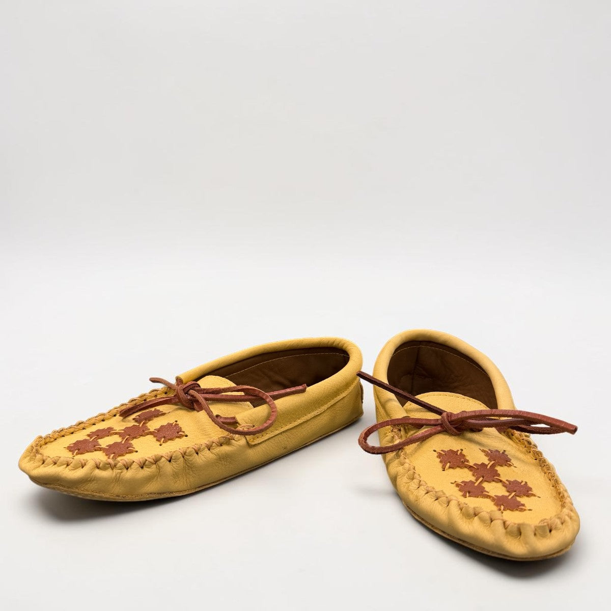 Alberta moccasins yellow caribou hide leather moccasins with a soft double leather sole and brown lace-up closure.
photo of the top side