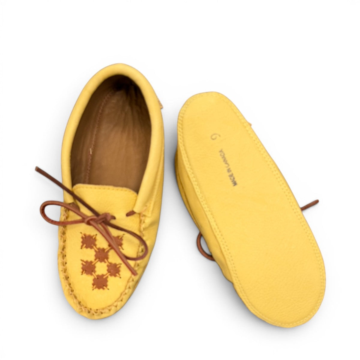 Alberta moccasins yellow caribou hide leather moccasins with a soft double leather sole and brown lace-up closure.
photo of the bottom side