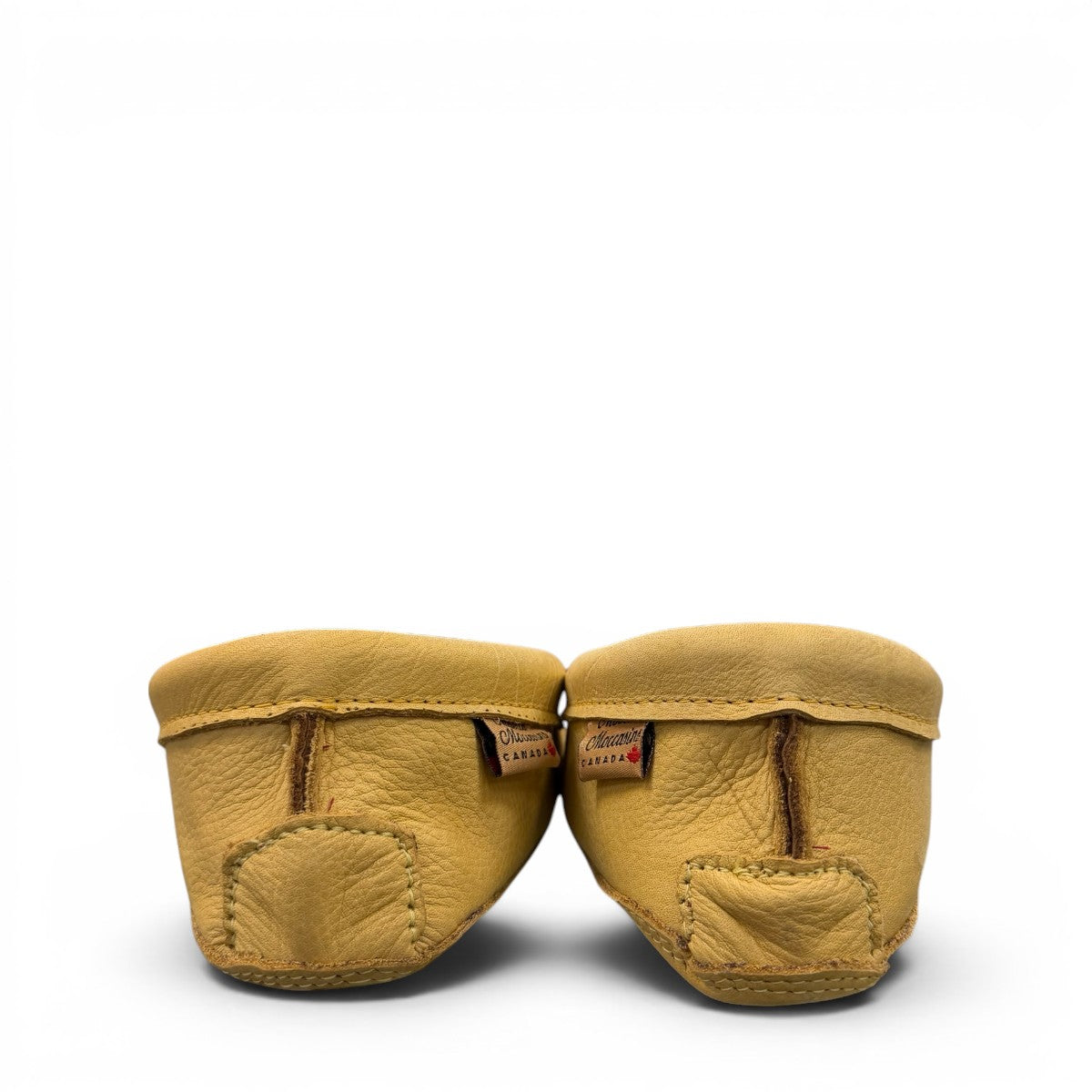 Alberta moccasins yellow caribou hide leather moccasins with a soft double leather sole and brown lace-up closure.
photo of the back side