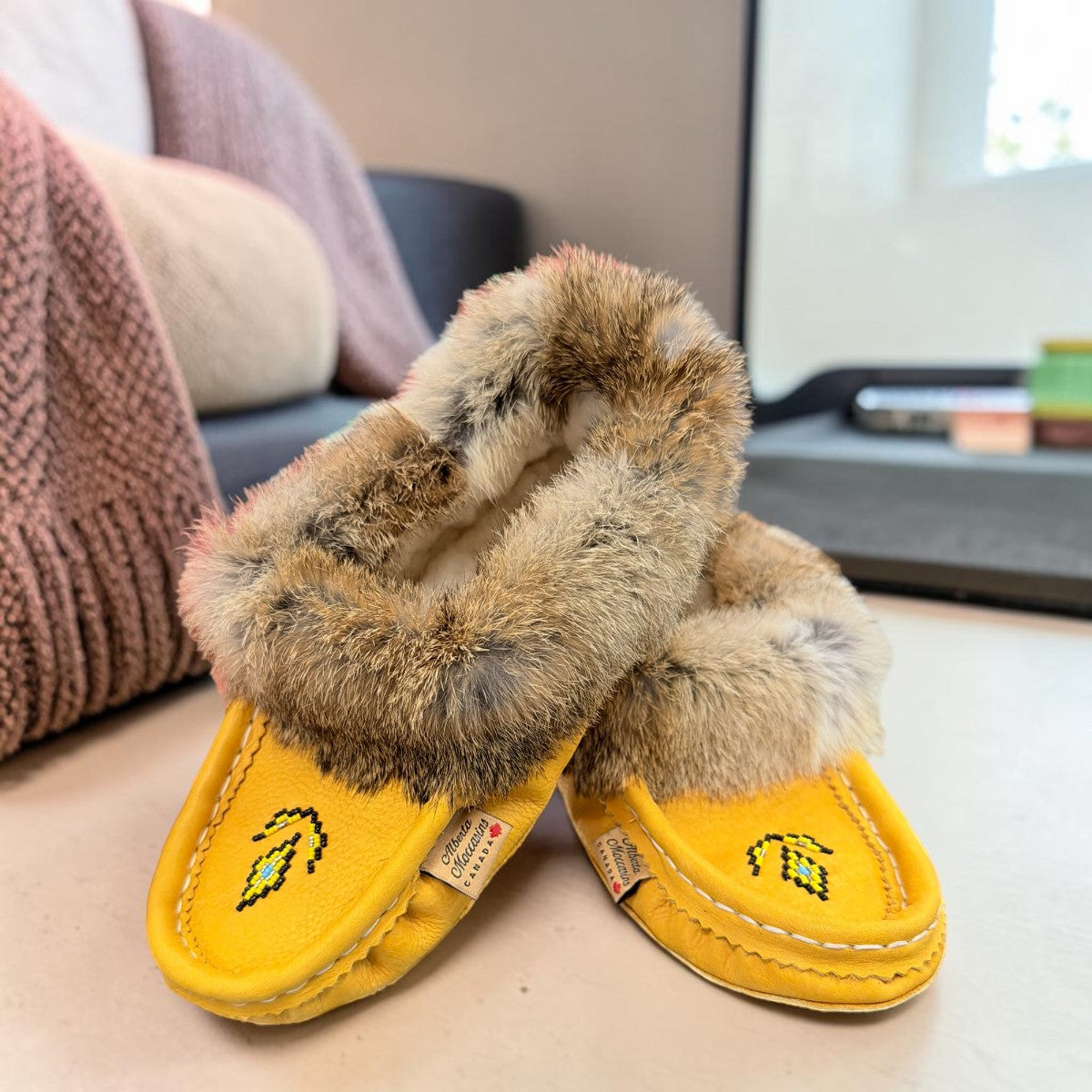 Alberta yellow suede moccasins with rabbit fur trim, handcrafted leather slippers for cozy everyday wear. Photo of front side view.