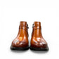 Brown leather ankle boots with a side buckle strap and durable rubber sole for formal wear. Photo of front view.