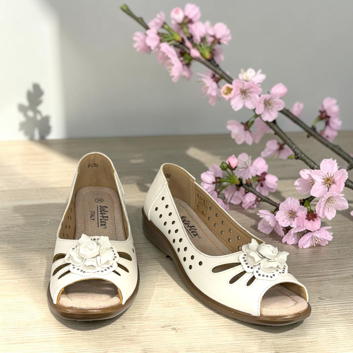 COLLEXION-F7067M white peep-toe comfort flats with floral detail, side perforations, and a flexible brown sole.
photo of the front side