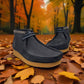 Sina Footwear blue leather Shacre boots with Wallabee-inspired design and rubber sole on an autumn leaf background. Photo at a front angle.