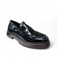 David Tyler black patent leather loafer with a chunky dark wood-effect sole and leather lining. Photo of front side view.