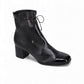 Django & Juliette Valina black leather ankle boots with patent toe, block heel, and lace-up detail. Photo of front side view.