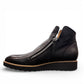 DJANGO & JULIET OHMY black leather ankle boot with asymmetrical front zipper and low wedge heel. Photo of left side view.