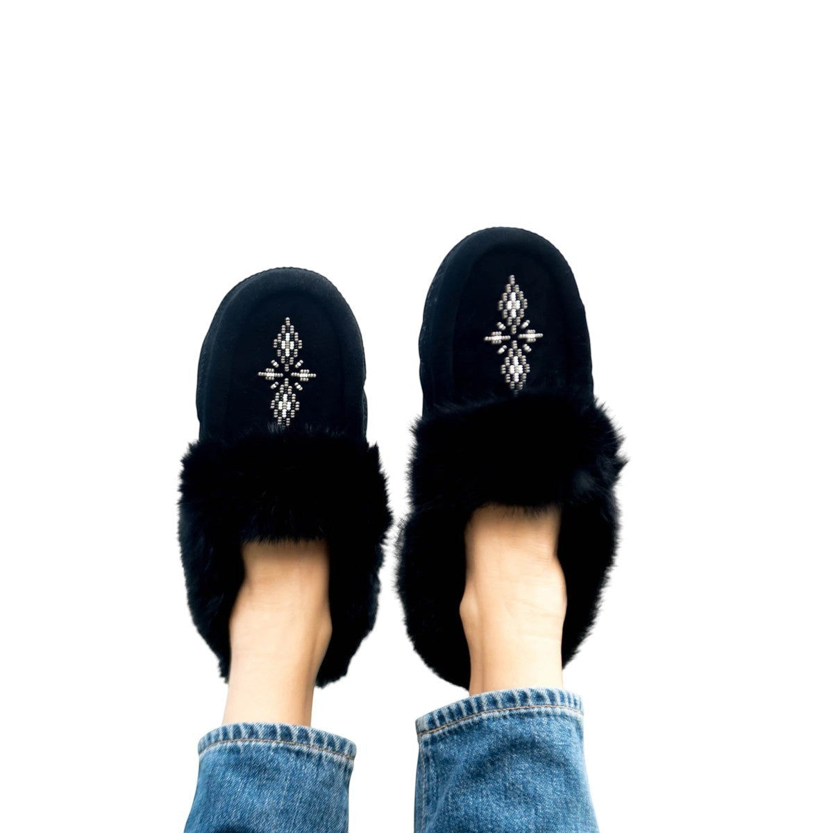 black suede Tipi moccasins with rabbit fur trim and intricate beadwork worn with blue jeans