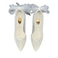 NIKPA SANA white bridal pump with glitter finish, pointed toe, and sheer tulle bow detail on the heel.