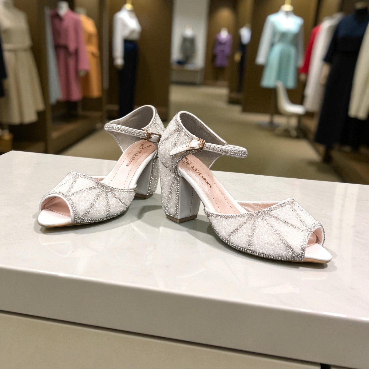 Nikpa lalala white synthetic bridal heels with intricate rhinestone detailing and an ankle strap in a ballroom