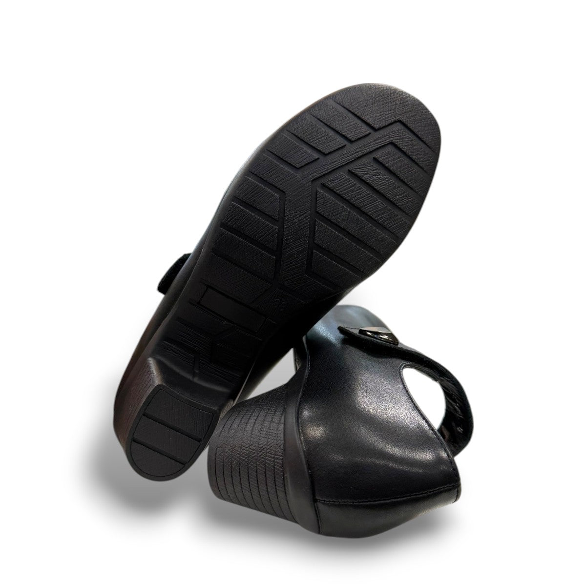 ORTHO-FLEX-F7108L black genuine leather Mary Jane shoe with an adjustable strap, metallic accent, and block heel.
photo of the bottom side