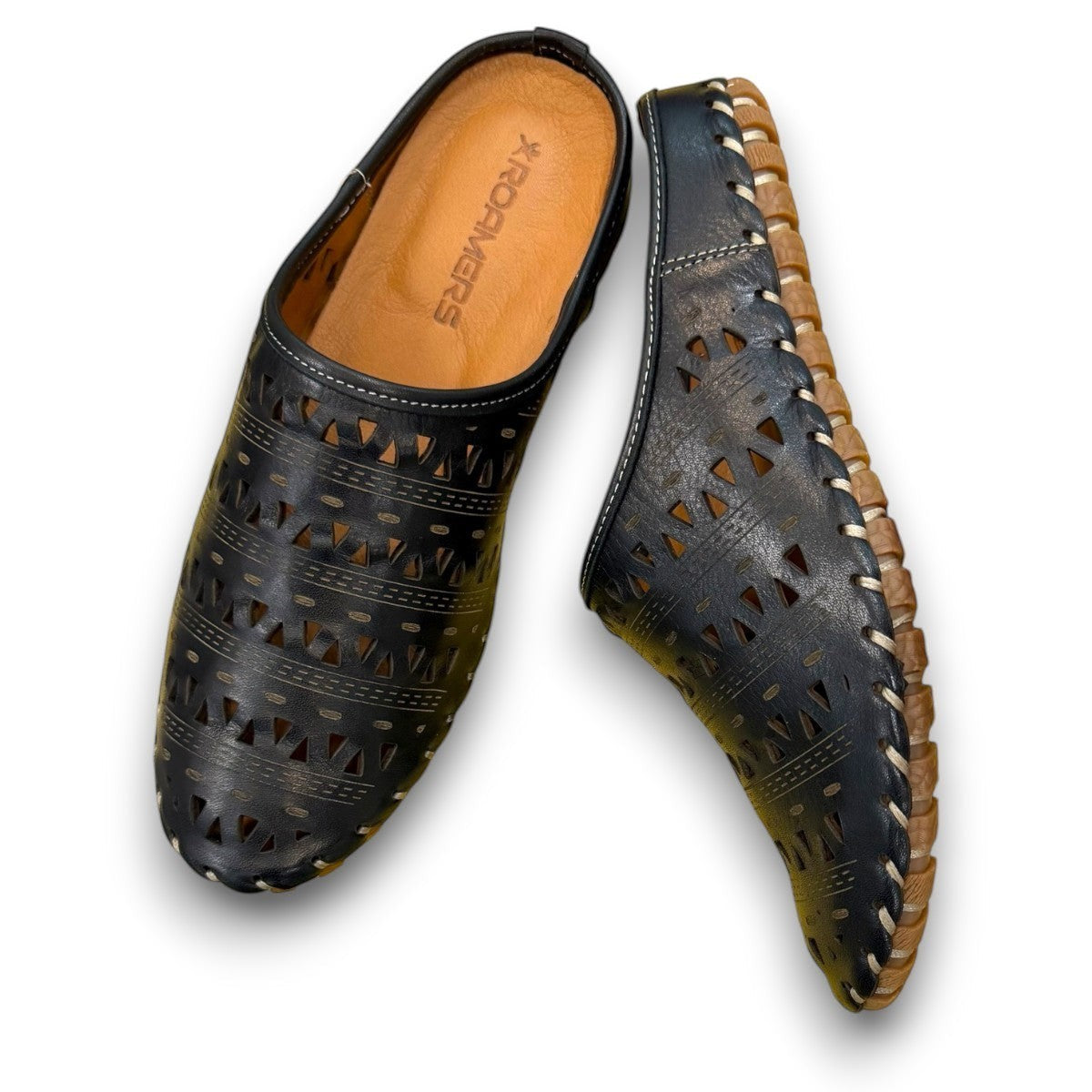 Roamers black leather slip-on mules with perforated cutouts and contrast stitching on a rubber sole.
photo of the top side