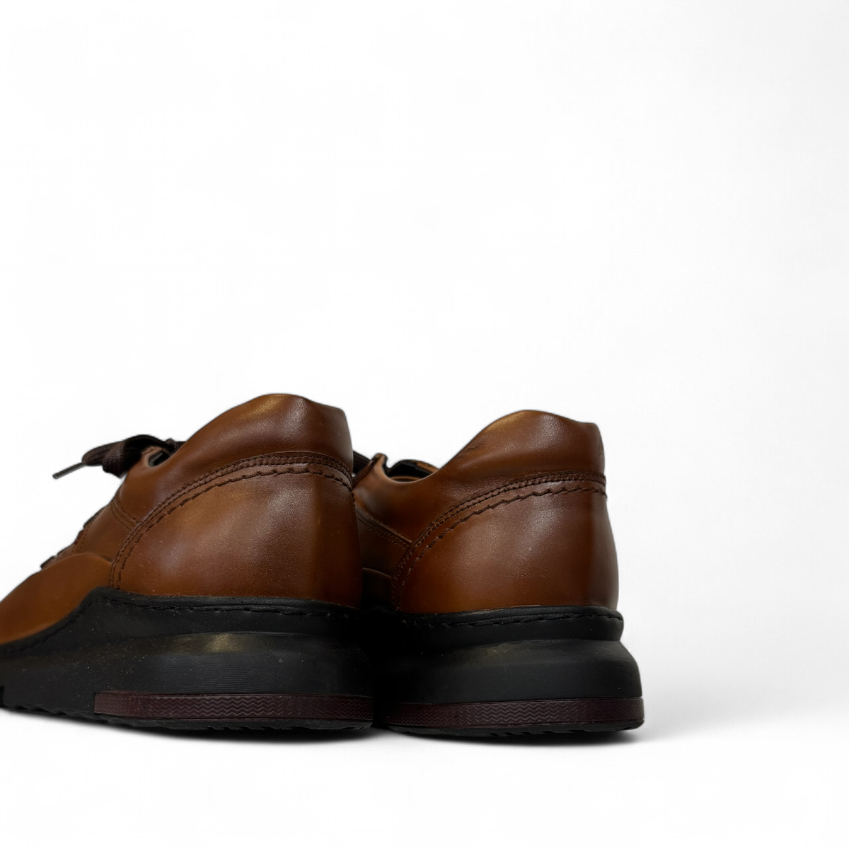 Satel Abgineh brown leather lace-up shoe with perforated detail and a durable black rubber outsole. Photo of back view.