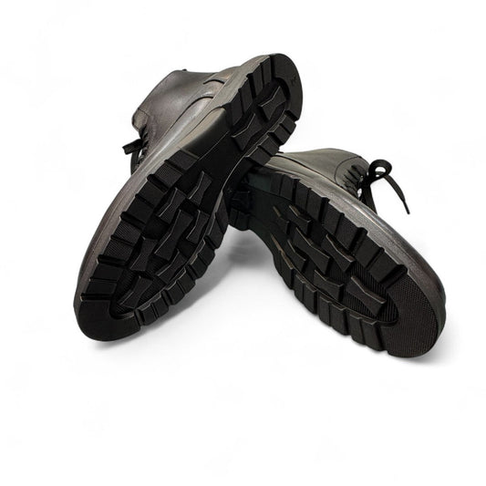 Satel Pooyan lace-up boots showing the durable lugged rubber outsoles from a bottom angle. Photo of bottom view.