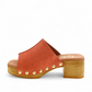Tyche Bella coral leather slip-on clog with gold rivet accents and a wooden block heel. Photo of left side view.