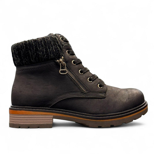 Wanderlust black ankle boot with faux leather, chunky knit cuff, side zipper, and lugged sole for winter comfort.