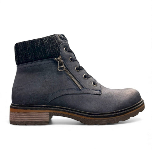 Wanderlust navy ankle boot with faux leather, chunky knit cuff, side zipper, lace-up closure, and lugged sole.