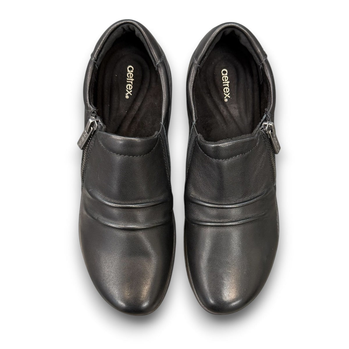 Aetrex Katie black leather casual shoe showing the durable rubber outsole and side zipper detail
