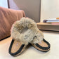 Alberta suede moccasins in coffee and black with a plush rabbit fur ankle collar and side stitching. Photo of front side view.