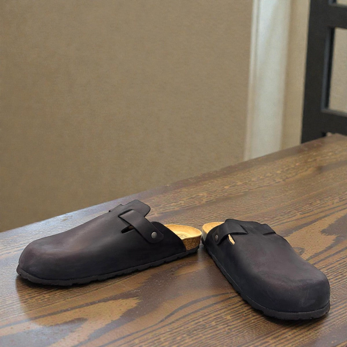Biotime Burly black leather clogs showing the textured EVA outsole and cork footbed from below.
