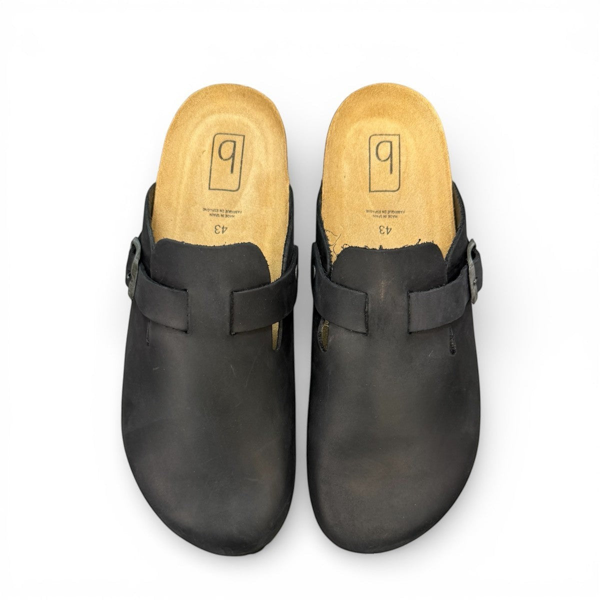 Biotime Burly black leather clogs showing the textured EVA outsole and cork footbed from below.