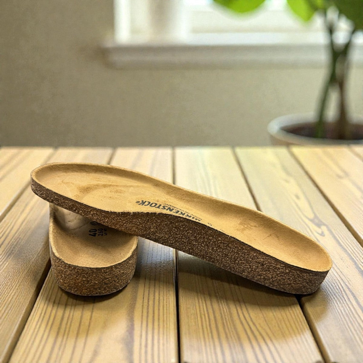authentic Birkenstock cork footbed replacement for sandal repair service on a wooden table