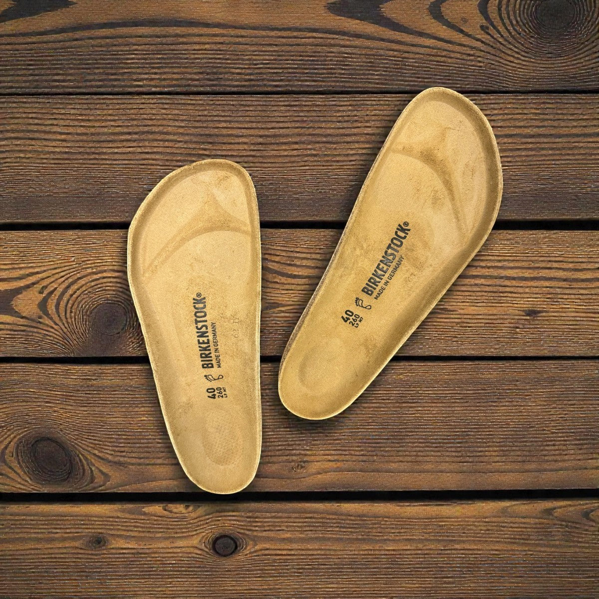 authentic Birkenstock cork footbed replacements for sandal repair on a rustic wooden background