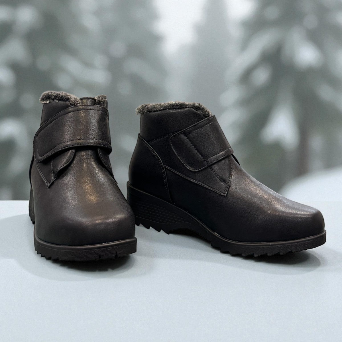 Canada Comfort black waterproof ankle boot with velcro strap and faux fur trim for winter traction. Photo of front side view 2.