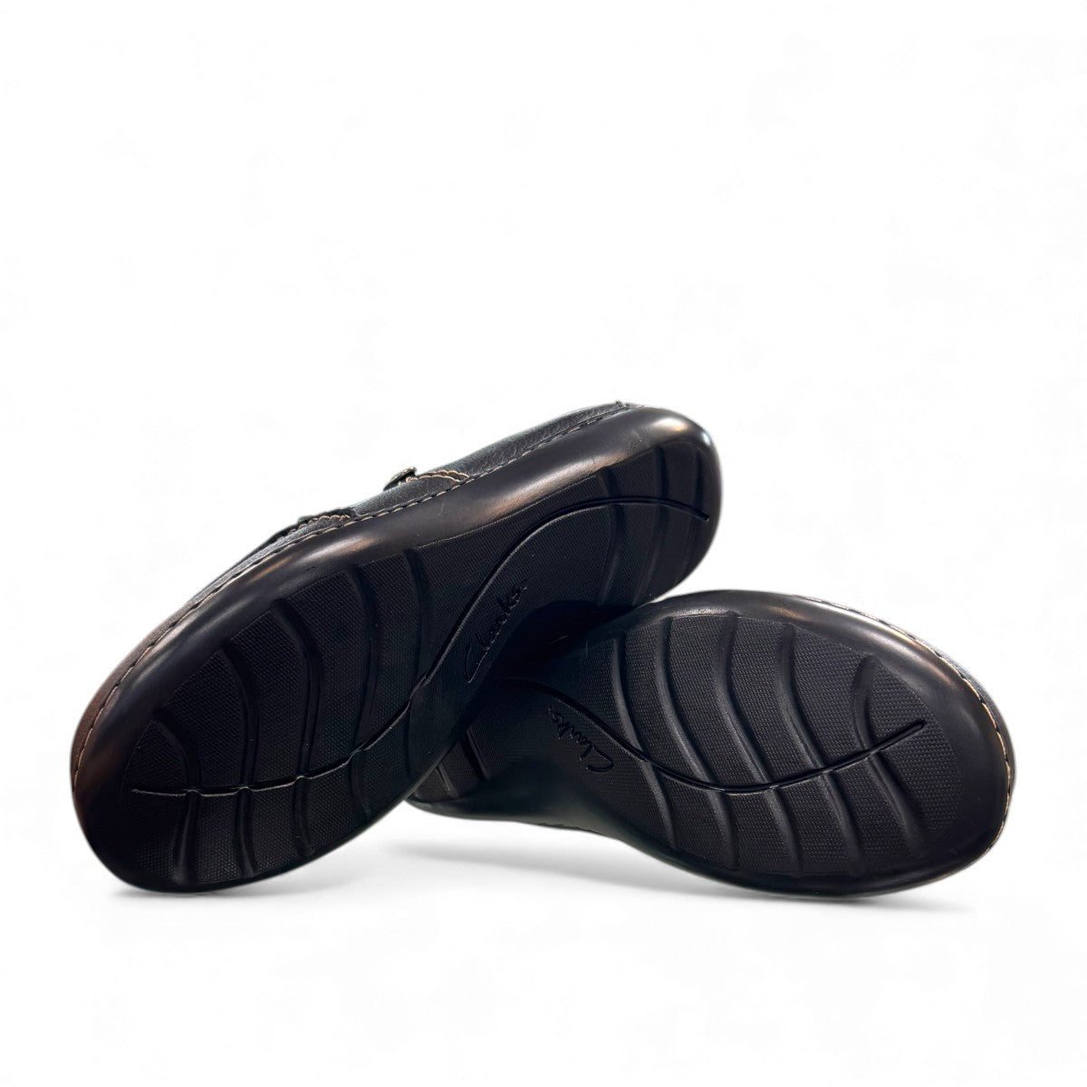 Clarks Ashland Lane Q black leather slip-on shoe with decorative buttons and contrast stitching. bottom view.