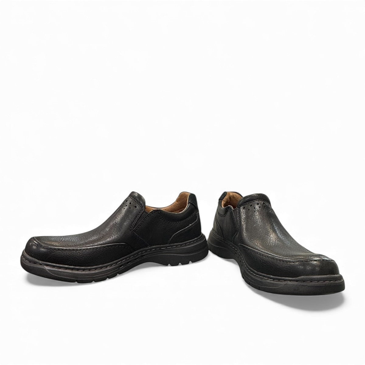 Clarks Un Brawley Step black leather slip-on shoe with textured rubber sole and stitched construction. photo of the front.