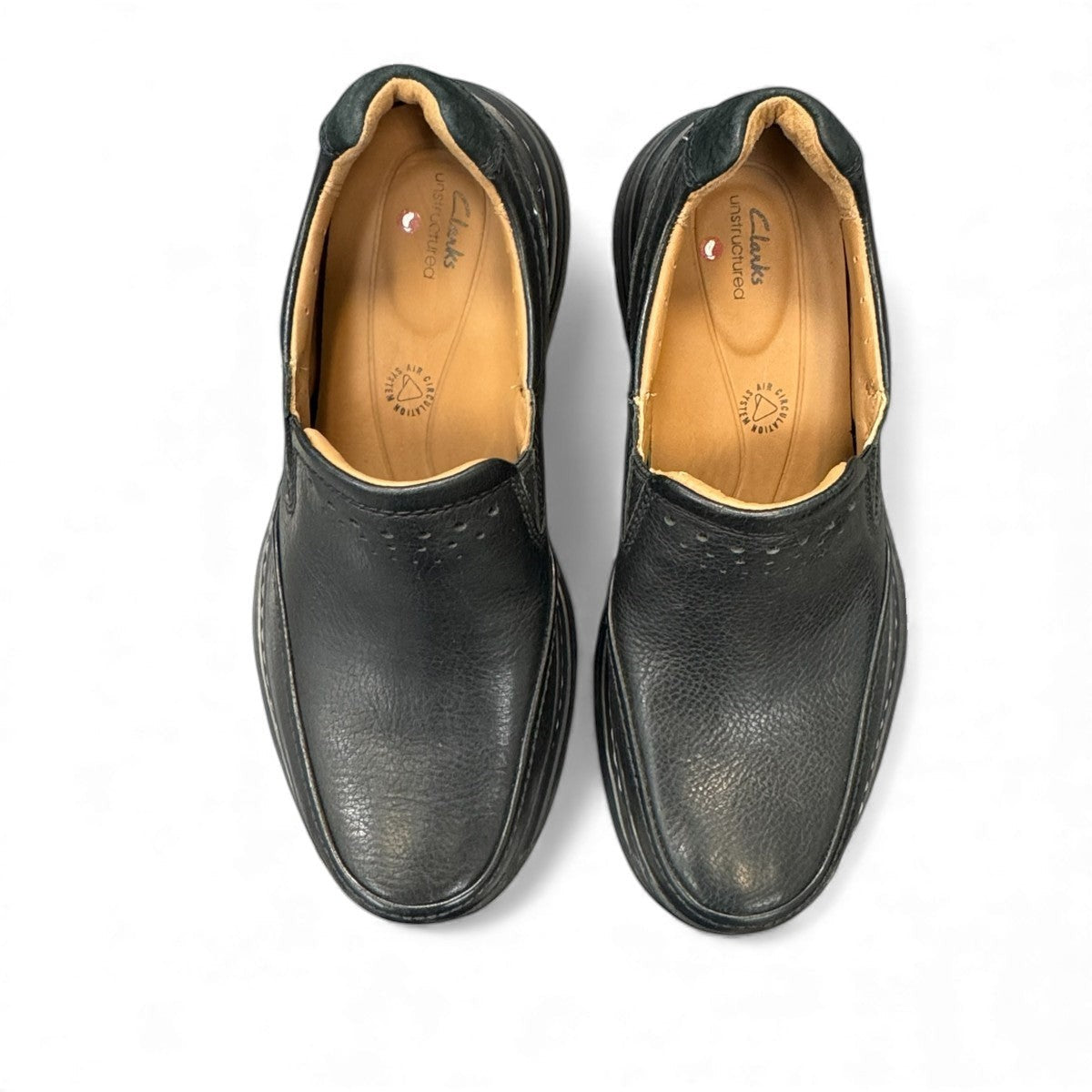 Clarks Un Brawley Step black leather slip-on shoe with textured rubber sole and stitched construction. photo of the top.
