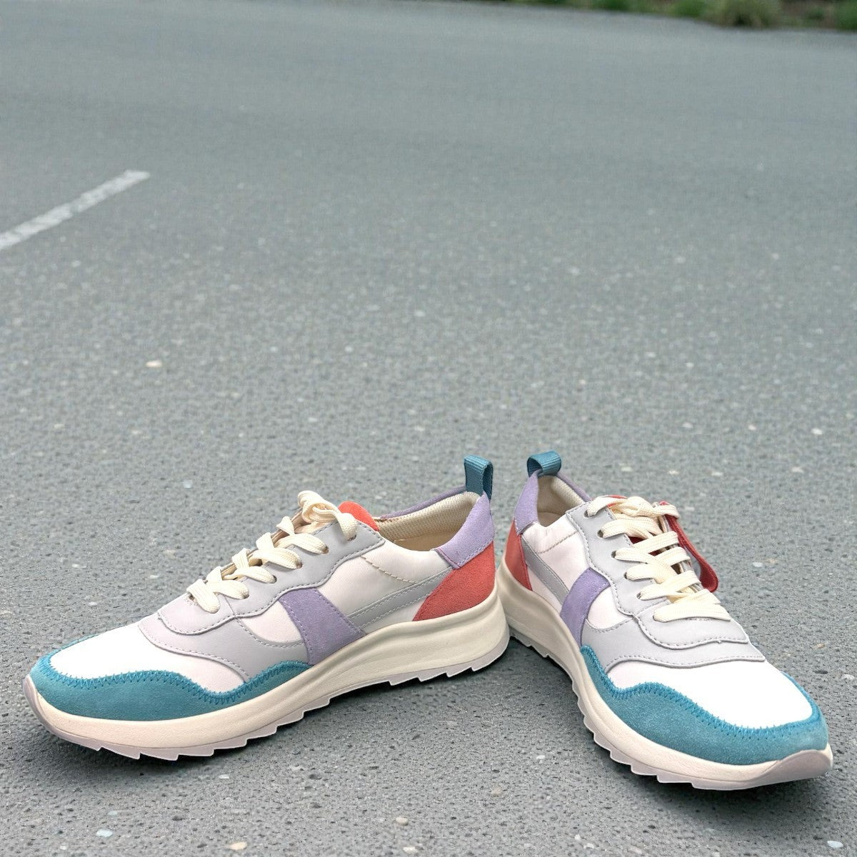 Clarks DashLite Jazz sneakers in lilac, teal, and coral leather with a retro jogger design and lace-up front. photo of the front.