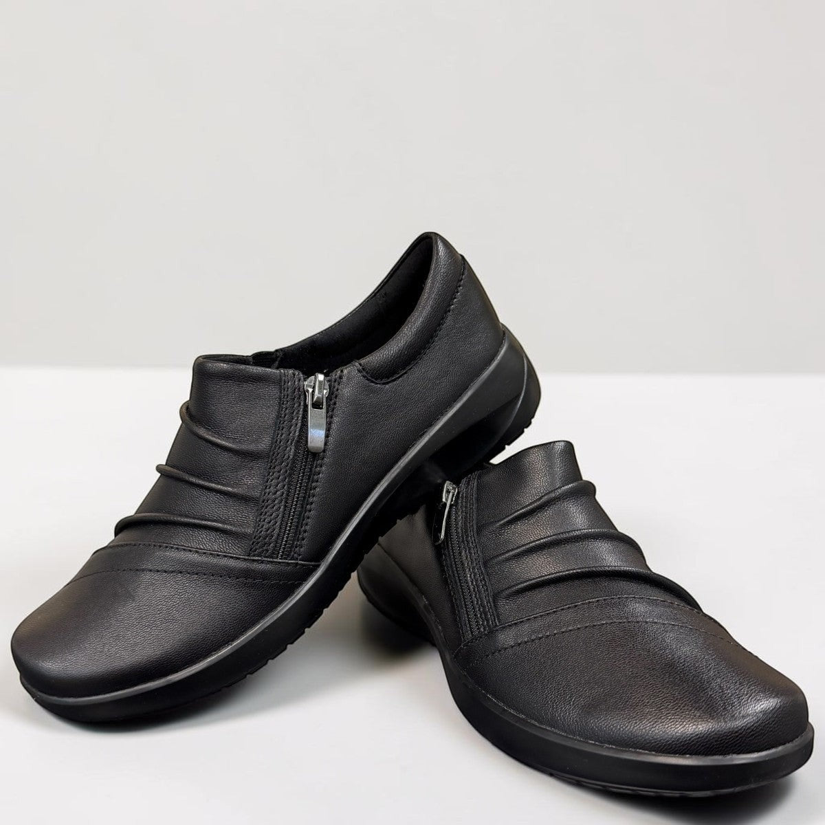 Sina Footwear Clarks Kaetlyn Mila black leather slip-on shoe with side zip and comfortable foam footbed.
photo of the front.