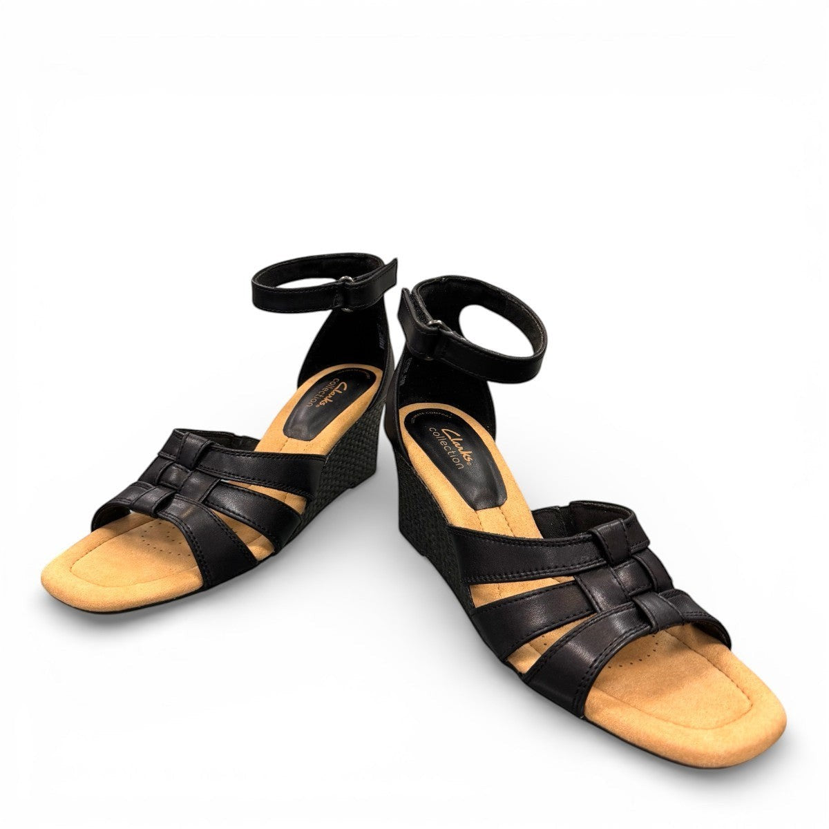 Clarks Kyarra Joy black leather wedge sandals with ankle strap and textured heel. front view.