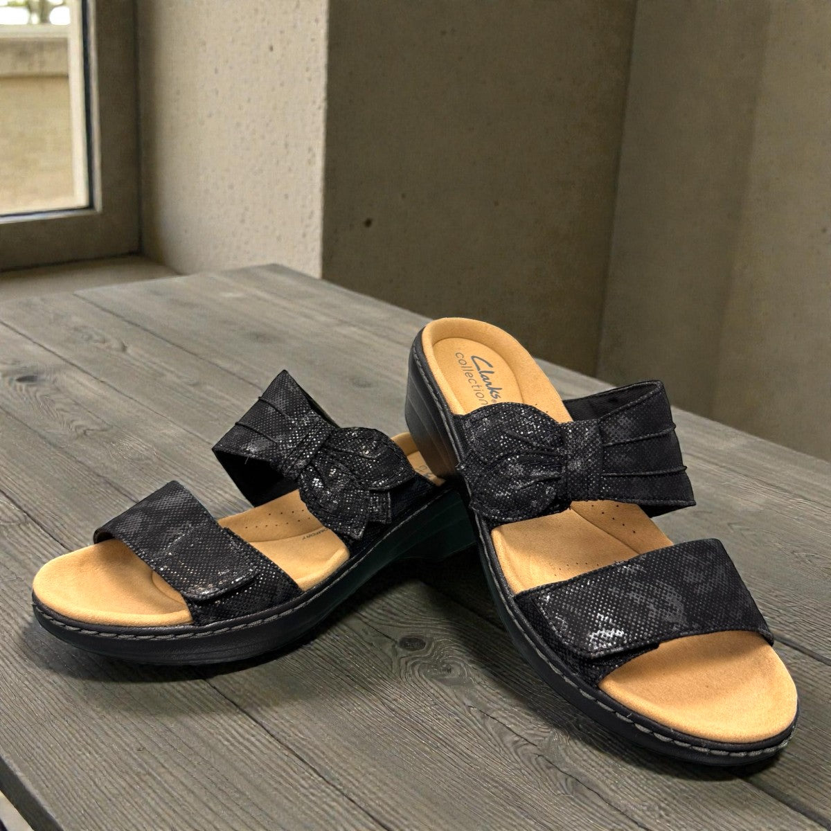 Clarks Merliah Charm black slide sandal with textile upper, and cushioned EVA sole. front view.