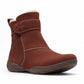 Clarks Roseville mahogany suede ankle boot with faux fur lining, adjustable strap, and textured sole. 
photo of the front.