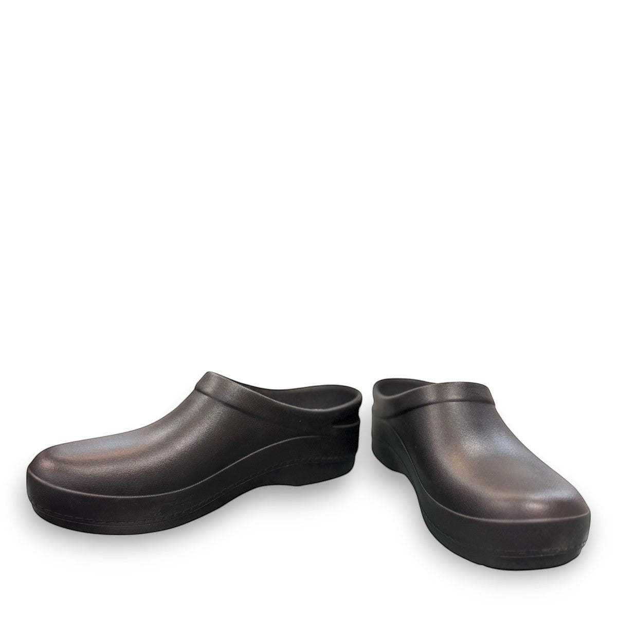 Dansko Kaci black molded EVA clogs showing the slip-resistant rubber outsole tread pattern. Photo of front view from an angle.
