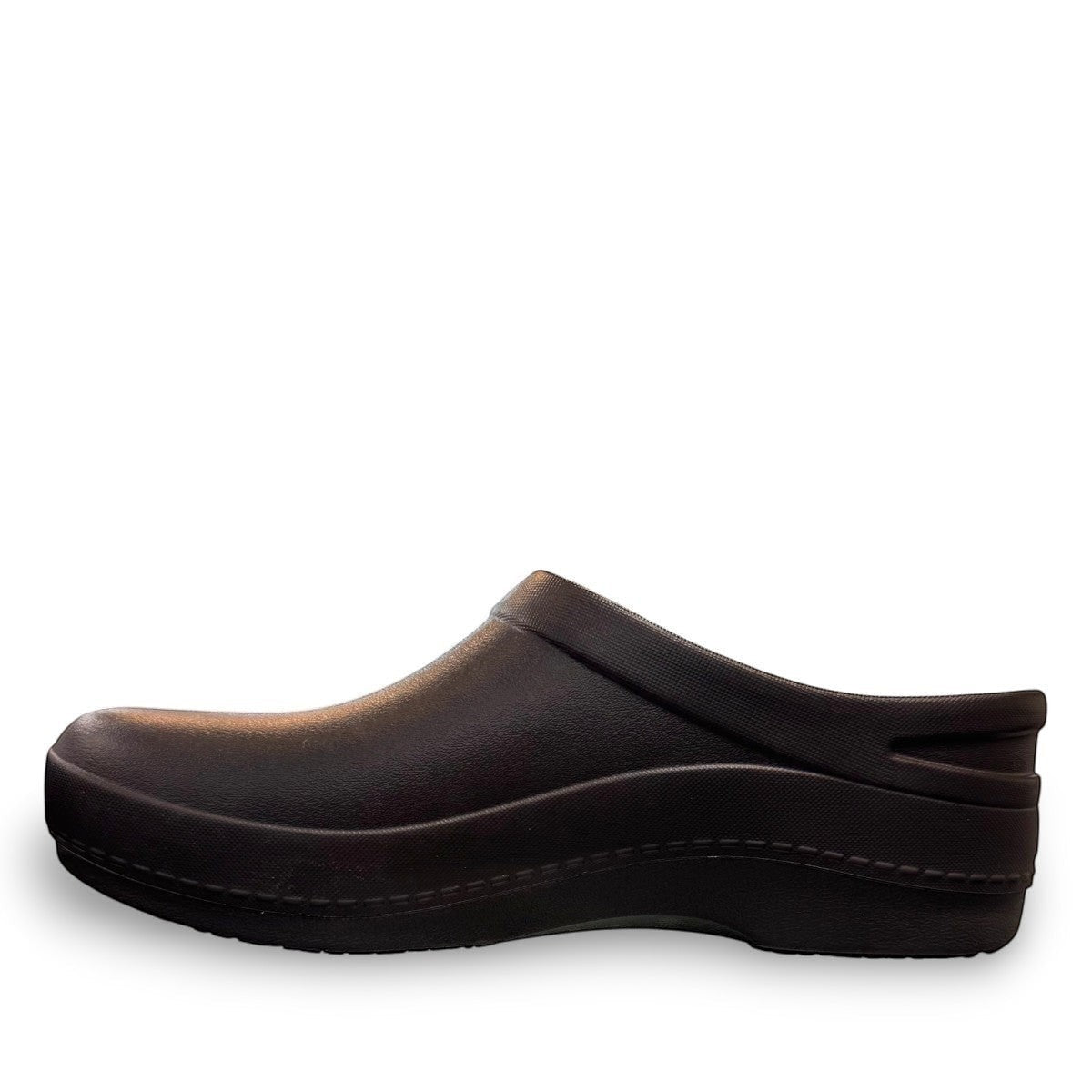 Dansko Kaci black molded EVA clogs showing the slip-resistant rubber outsole tread pattern. Photo of outside side view.