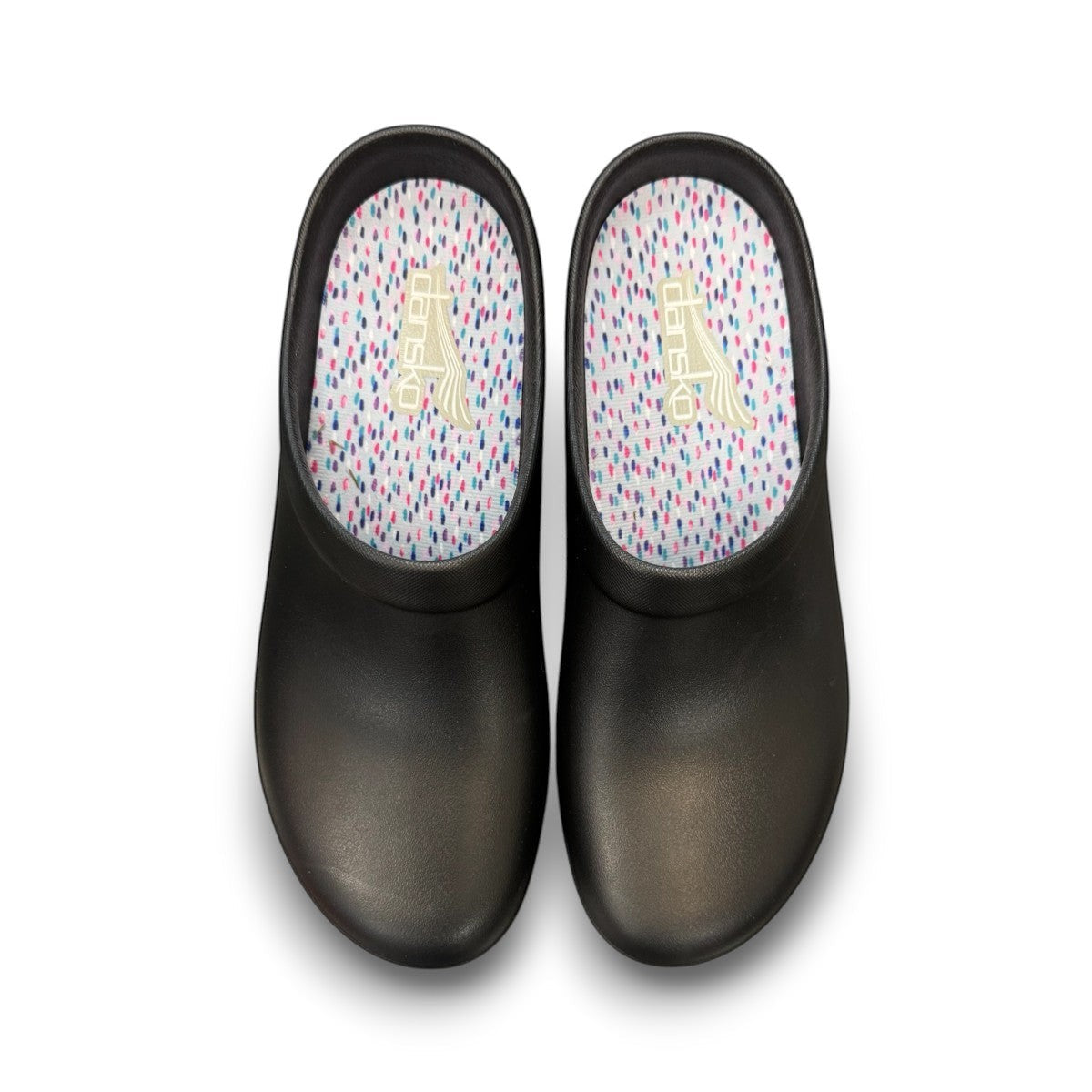 Dansko Kaci black molded EVA clogs showing the slip-resistant rubber outsole tread pattern