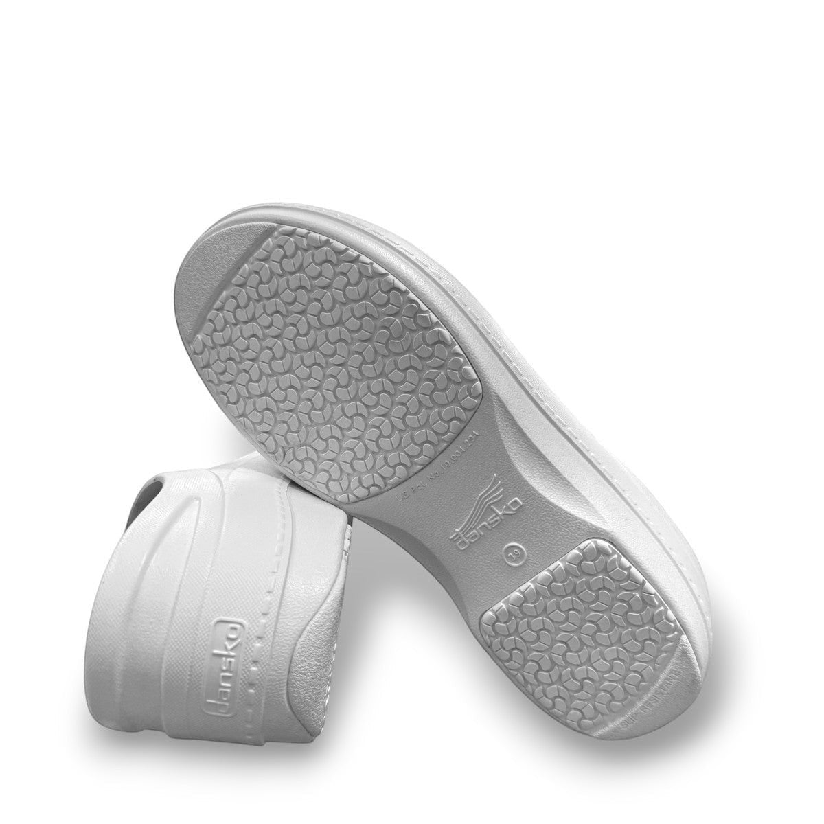 Dansko Kaci white molded EVA clogs showing the slip-resistant rubber outsole and arch support design. Photo of bottom view.